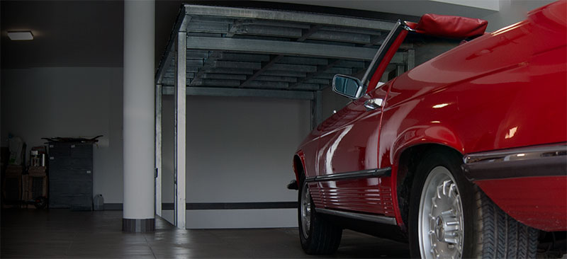Hydrauliczny garaż podziemny przed czerwonym Mercedesem cabrio